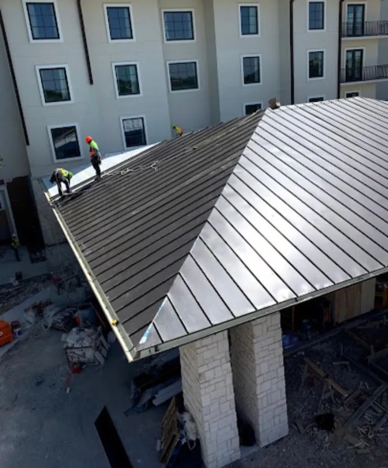 Crew installing standing seam metal roof panels on a commercial project in Deltona
